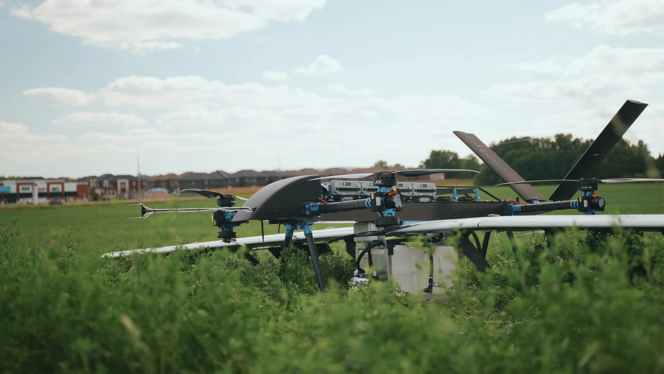 A wide view of the U9 Spray standing in a field with trees and open ground behind it.